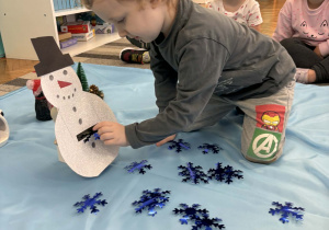 Chłopiec wrzuca niebieskie śnieżynki