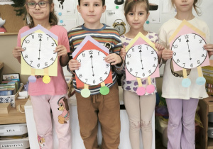 Dzieci na tle dni tygodnia stoją z zegarami