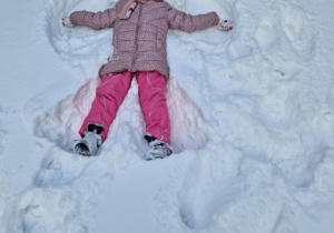 Dziewczynka robi aniołka na śniegu