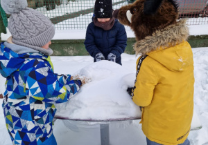 Dzieci przy śnieżnym stoliku