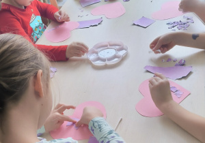 Dzieci smarują klejem serduszka