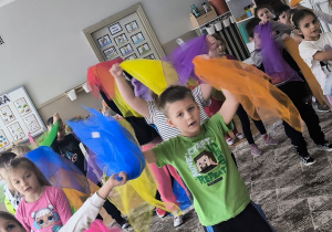 Dzieci machają w górze apaszkami