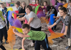 Dzieci robią młynek trzymając apaszki w ręku