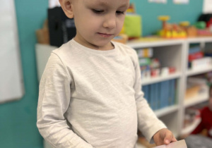 Chłopiec patrzy na zdjęcie wróbla