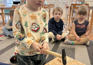 Chłopiec wbija gwóźdź