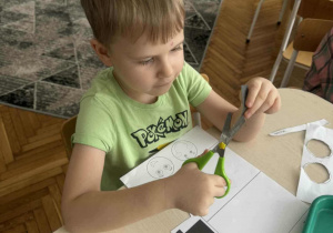 Chłopiec wycina nożyczkami