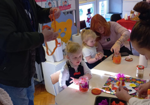 dziadkowie z wnuczkami ozdabiają lampiony zimowe