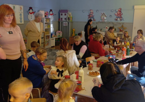 dziadkowie z wnuczkami ozdabiają lampiony zimowe