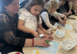 Dziewczynka przykleja naklejkę na obrazek