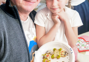 Dziadek z wnusią z udekorowanymi ciastkami