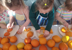 Dziewczynki kroją na drobne kawałki owoce