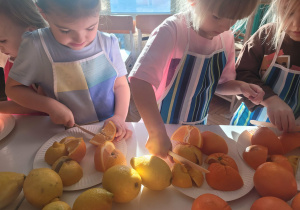 Dziewczynki kroją owoce cytrusowe