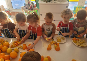 Dzieci kroją owoce cytrusowe na drobne kawałki