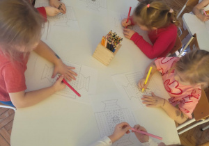 Dzieci przy stole kolorują serduszka