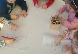 Dzieci kolorują ramkę z babcią i dziadkiem