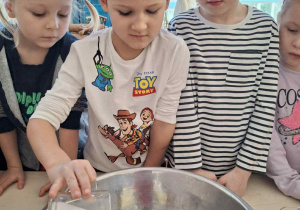 Chłopiec wsypuje sól do miski