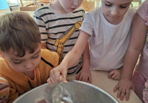 Dziewcyznka zalewa woda makę w misce