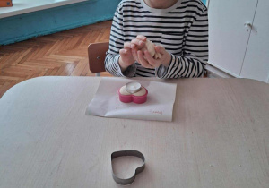 Chłopiec wycina foremką serce