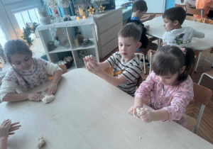 Dzieci przy stoliku ugniataja mase solną