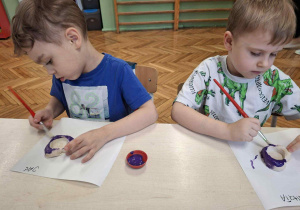 Chłopcy maują na fioletowo świeczniki