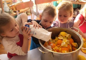 dzieci wsypują cukier do garnka