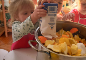 dzieci wsypują cukier do garnka