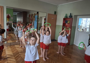 Dzieci w parach stoją tyłem i podnoszą koła