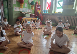 Dzieci siedzą w siadzie skrzyżnym