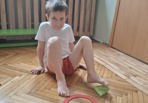 Chłopiec palcami stóp łapie woreczek