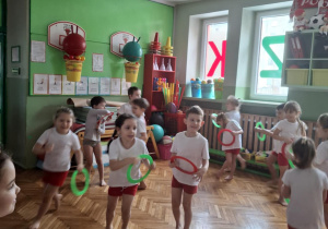 Dzieci bez potrąceń biegają po sali z kółkami