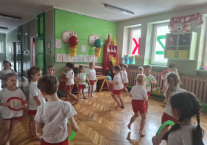 Dzieci stoją po obwodzie koła z malymi kółkami