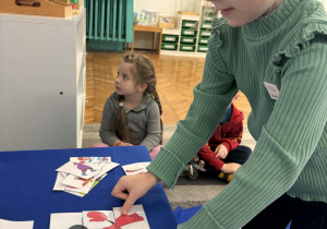 Dziewczynka składa obrazek z części