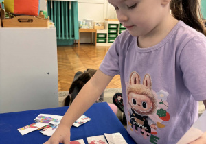 Dziewczynka uklada obrazek bałwanka z części