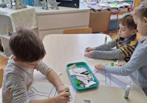 Chłopiec nakleja kawałki gazet