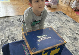 Chłopiec wyciąga ilustrację z magicznego pudełka