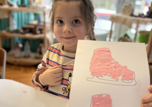 Dziewczynka pokazuje różowe łyżwy