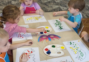 Dzieci stempluja maski farbami