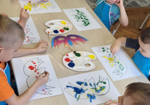 Dzieci malują maski farbami