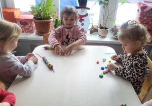 Dziewcyznki nawlekają korale z pianki