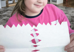Dziewczynka pokazuje wycinankową serwetkę