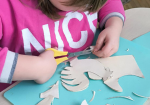 Dziewczynka wycina wycinankę łowicką