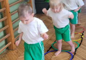 Dzieci przechodzą po kołach ułozonych na ziemi