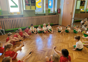 Dzieci stopami podnoszą woreczek do góry