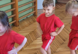 Chłopiec maszeruje z rekoma na biodrach