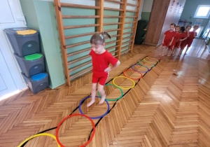 Dziewczynka przechodzi przez kolorowe obręcze