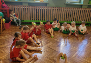 Dzieci stopami podnoszą woreczek do góry