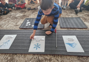 Chłopiec układa z sylab słowo zima