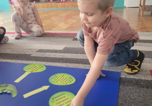 Chłopiec układa jajo dinozaura obok dużej sylwety