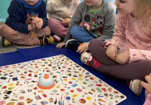 Dzieci odszukują na planszy wylosowane elementy