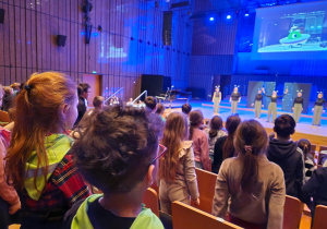 Dzieci stoją przed sceną